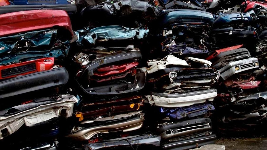 Car scrapyard, pile of crushed vehicles in junk yard