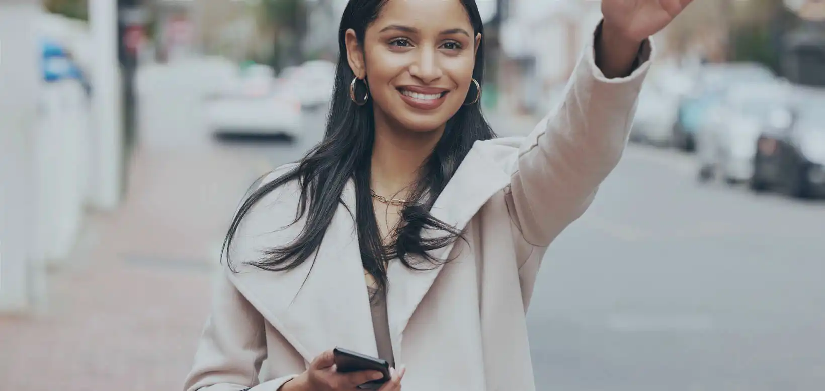 a lady waves for taxi