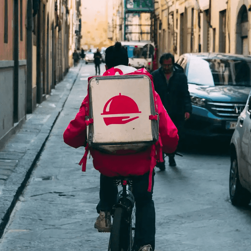Rear view of a food delivery rider on a bicycle