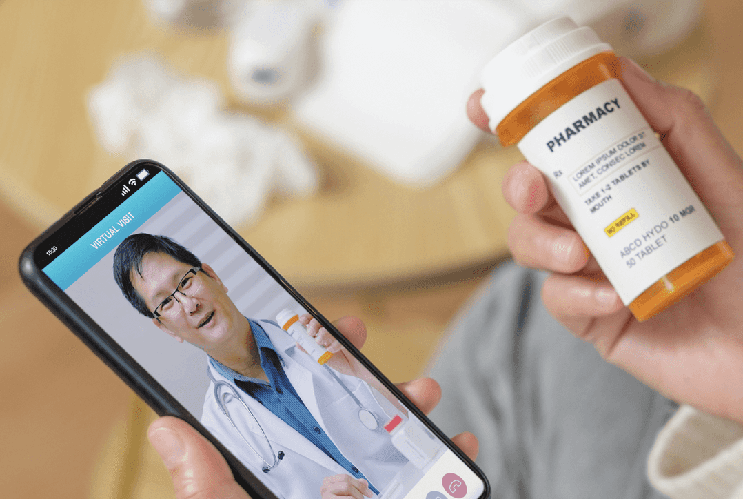 mHealth concept; close up of a person holding a smartphone and medication while in video call with a medial professional